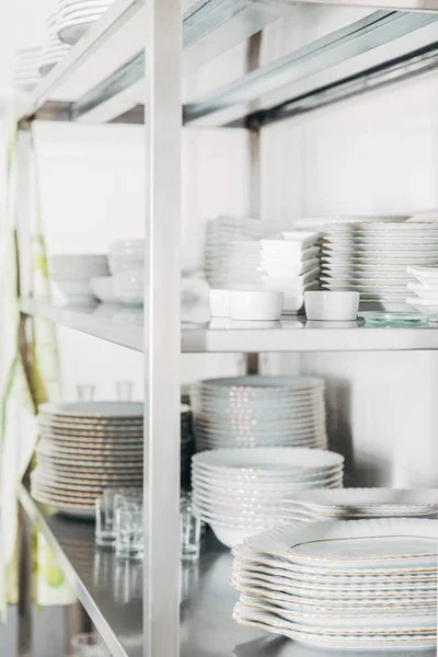 Close-up shot of stacked clean tableware on shalves at restaurant — Stock Photo