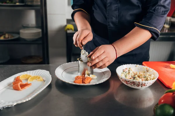 Colpo ritagliato di chef preparare insalata con tubo di metallo formando al ristorante — Foto stock