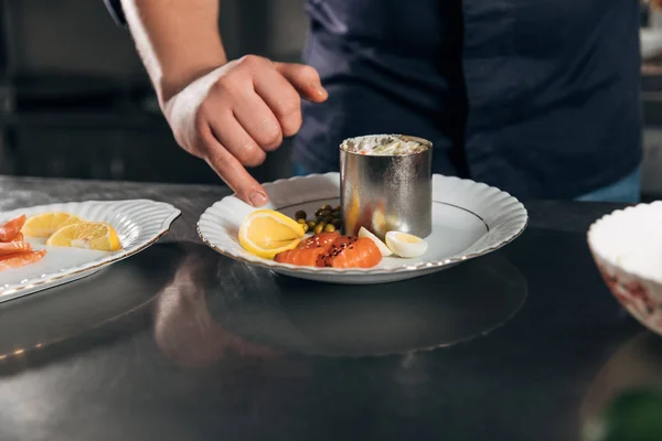Tiro recortado de chef preparando ensalada en el restaurante - foto de stock
