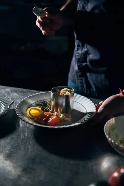 Colpo ritagliato di chef preparare insalata con tubo di metallo formando al ristorante — Foto stock