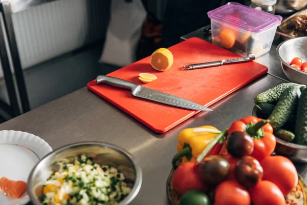 Divers ingrédients et planche à découper sur la table au restaurant cuisine — Photo de stock