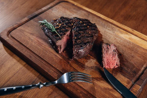 Close-up shot of delicious medium rare grilled steak on wooden board — Stock Photo