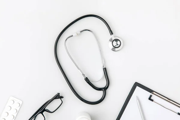 Stethoscope near glasses and paper in folder laying isolated on white background — Stock Photo