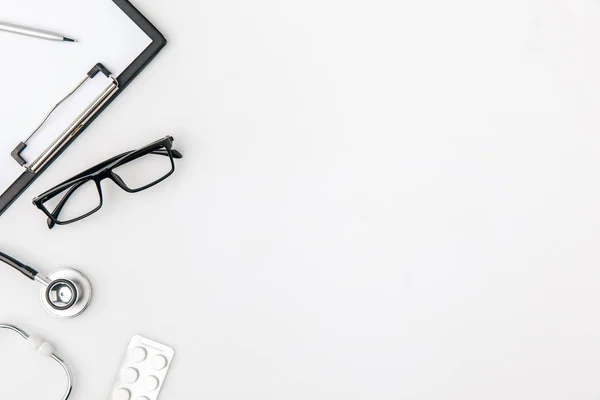 Brille in der Nähe von Ordner mit Papier und Stethoskop isoliert auf weißem Hintergrund — Stockfoto