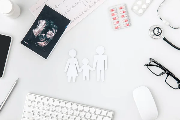 White silhouette of family surrounded by pills, keboard, photo, glasses isolated on white background — Stock Photo