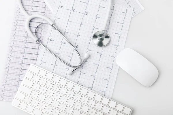 Stethoskop, Tastatur und Computermaus auf Papier, Kardiogramm isoliert auf weißem Hintergrund — Stockfoto