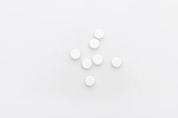 Scattered white pills isolated on white background — Stock Photo