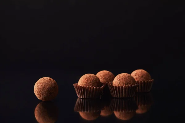 Close up view of tasty truffles on black — Stock Photo