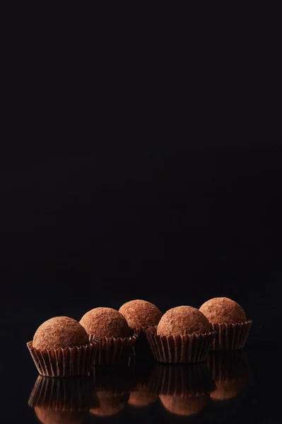 Close up view of tasty truffles on black — Stock Photo