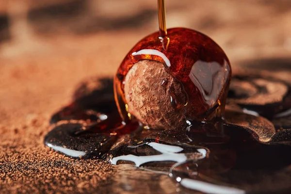 Close up view of pouring caramel onto truffle process — Stock Photo