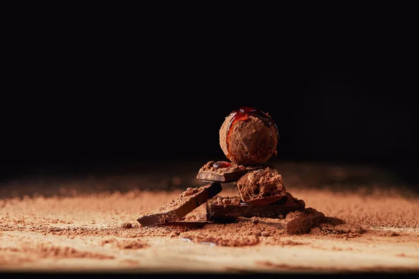 Close up view of arrangement of truffle with caramel and chocolate bars on black — Stock Photo