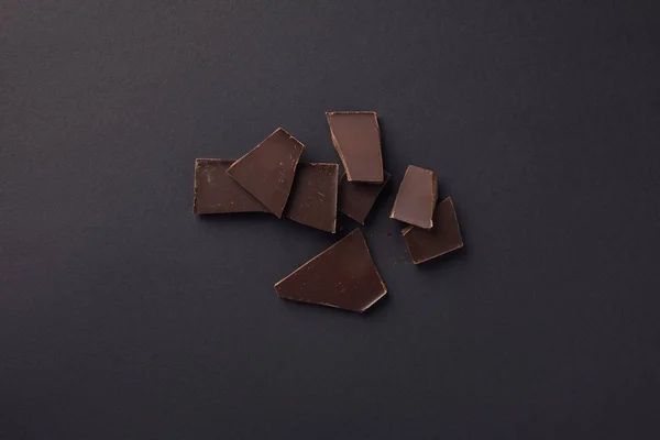 Draufsicht auf dunkle Schokoladentafeln auf grauer Oberfläche — Stockfoto