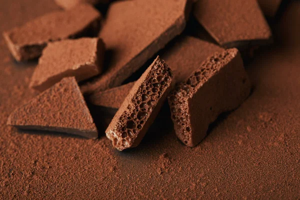 Primer plano vista de montón de barras de chocolate en polvo de cacao - foto de stock