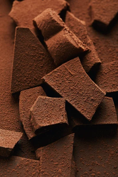 Primer plano vista de montón de barras de chocolate en polvo de cacao - foto de stock