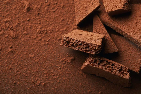 Vista de perto de montão de barras de chocolate em pó de cacau — Fotografia de Stock