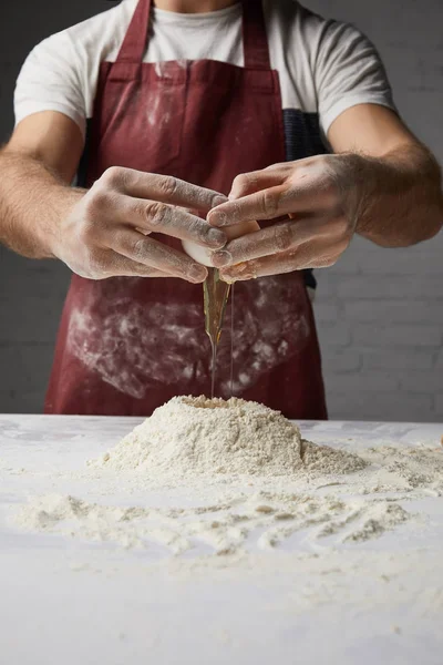 Cropped image of chef preparing dough and adding egg — Stock Photo