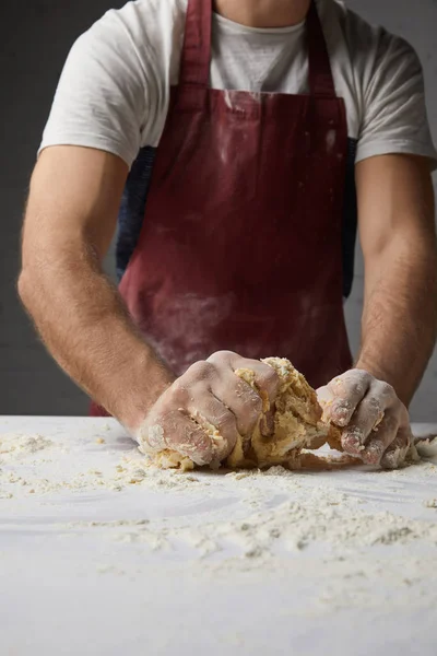 Imagem cortada do chef amassar massa na mesa — Fotografia de Stock