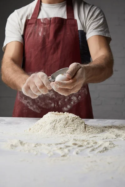 Cropped image of chef preparing dough and breaking egg — Stock Photo