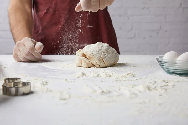 Abgeschnittenes Bild des Chefs, der Teig zubereitet und Mehl hinzufügt — Stockfoto