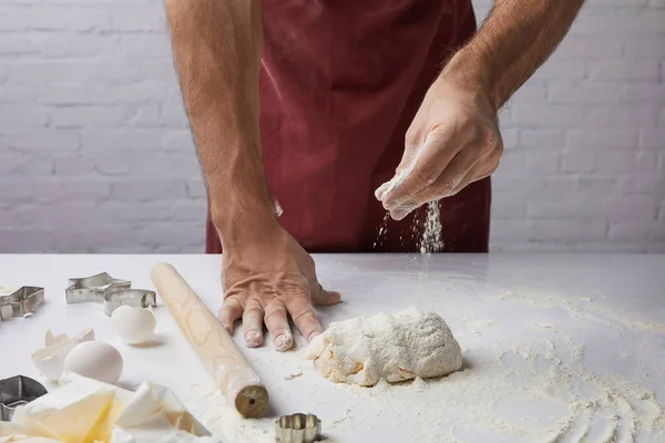 Обрізане зображення шеф-кухаря, що додає борошно до тіста — стокове фото