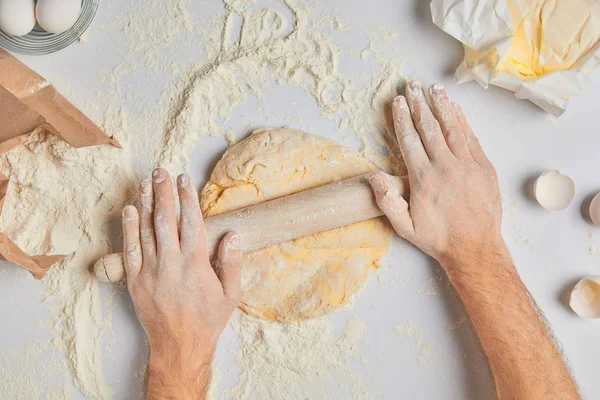 Cropped image of chef rolling dough with rolling pin — Stock Photo