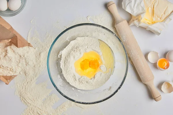 Top view of eggs and flour in glass bowl — Stock Photo