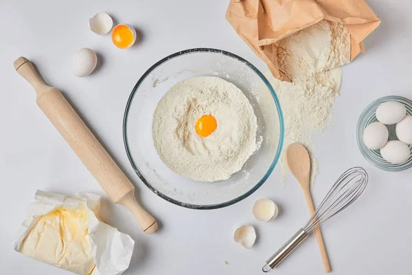 Top view of glass bowl with flour and egg on table — Stock Photo