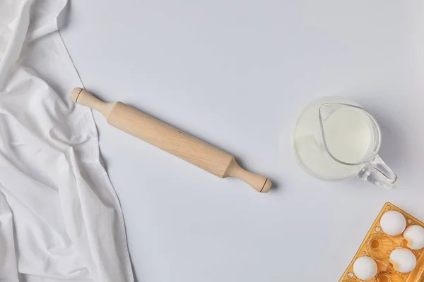 Top view of tablecloth, rolling pin and milk on table — Stock Photo
