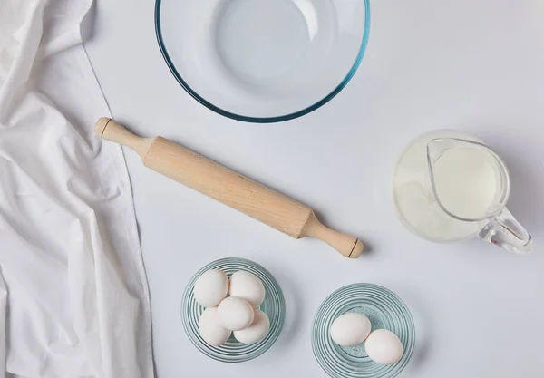 Vue du dessus des œufs, rouleau à pâtisserie et lait sur la table — Photo de stock