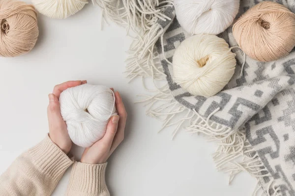 Cropped view of woman holding white yarn ball on white background — Stock Photo