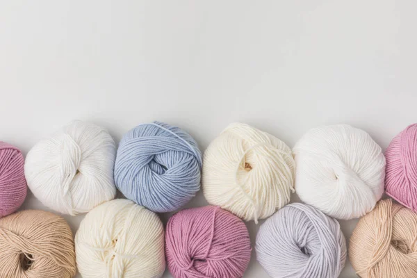 Vue de dessus des boules de fil colorées dans une rangée isolée sur fond blanc — Photo de stock