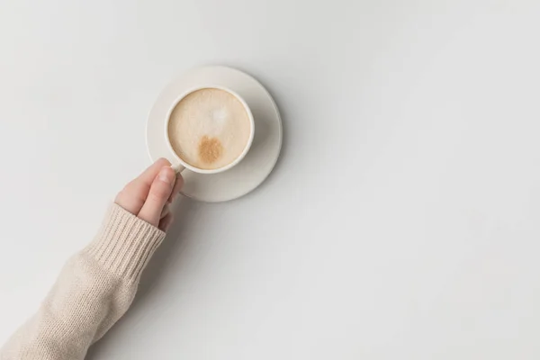 Vista recortada de la mujer sosteniendo la taza de café en la mano sobre fondo blanco - foto de stock