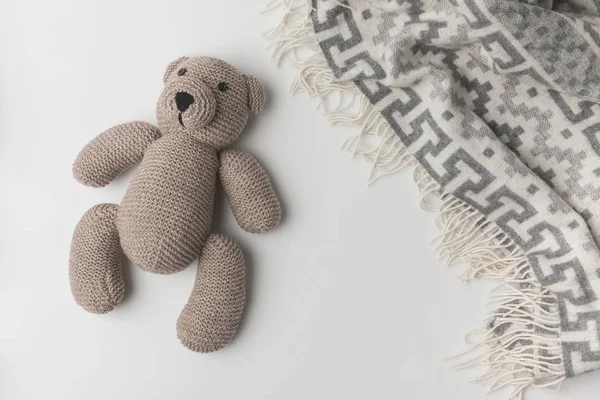 Draufsicht auf Teddybär, der in der Nähe einer Decke auf weißem Hintergrund liegt — Stockfoto