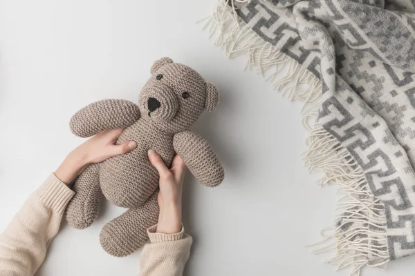 Vista recortada de la mujer sosteniendo osito de peluche en las manos sobre fondo blanco - foto de stock