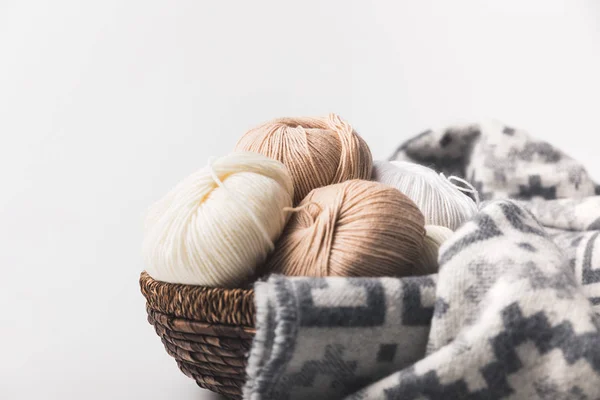 Bolas de hilo de colores en canasta de mimbre con manta aislada en blanco - foto de stock