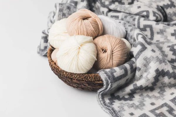Цветные пряжи шары в плетеной корзине с одеялом изолированы на белом — стоковое фото