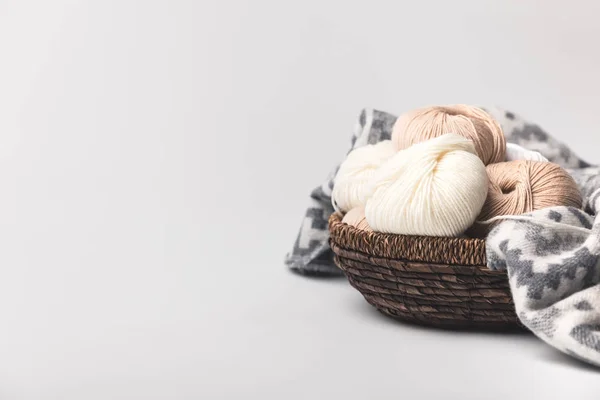 Colored yarn balls in wicker basket with blanket isolated on white — Stock Photo