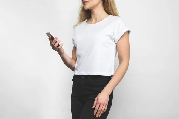 Recortado tiro de mujer en blanco camiseta en blanco - foto de stock