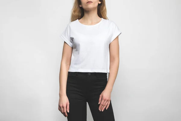 Ritagliato colpo di giovane donna in bianco t-shirt su bianco — Foto stock