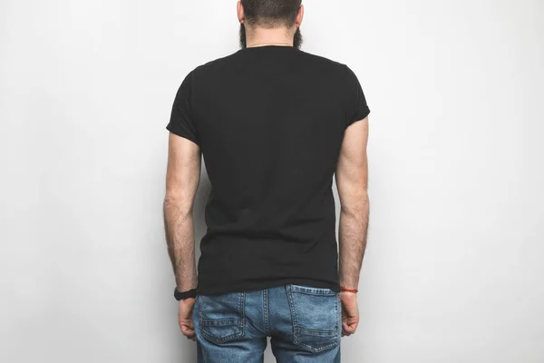 Vista trasera del hombre en camiseta negra aislada en blanco - foto de stock