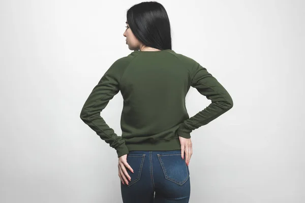 Back view of young woman in blank green sweatshirt on white — Stock Photo