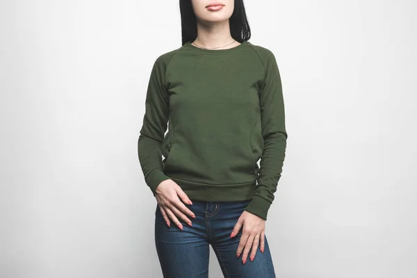 Cropped shot of young woman in blank green sweatshirt on white — Stock Photo