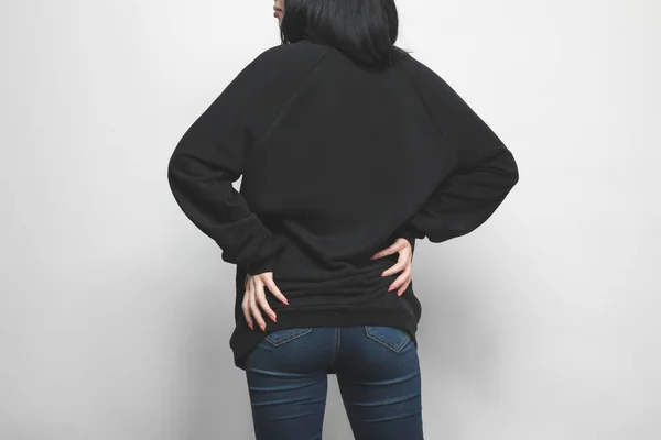 Rear view of young woman in black hoodie on white — Stock Photo