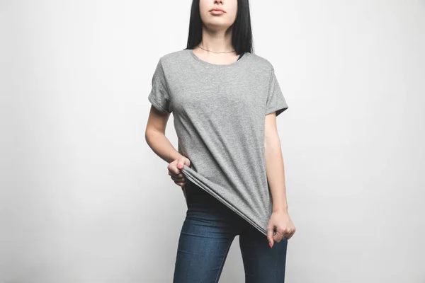 Attractive young woman in blank grey t-shirt on white — Stock Photo