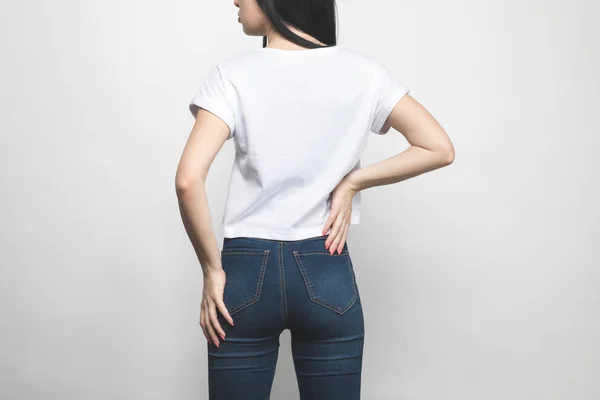 Back view of attractive young woman in blank t-shirt on white — Stock Photo