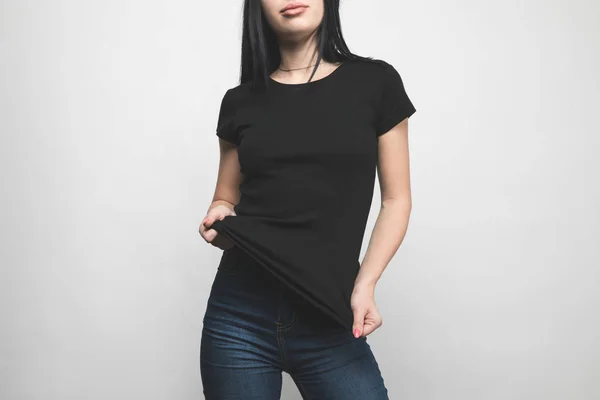 Stylische junge Frau in schwarzem T-Shirt auf weißem Grund — Stockfoto