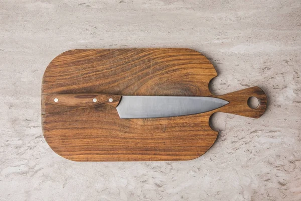 Top view of knife on cutting board on marble table — Stock Photo