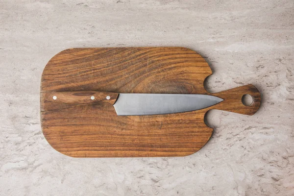 Vue du dessus du couteau sur la planche à découper sur la table en marbre — Photo de stock