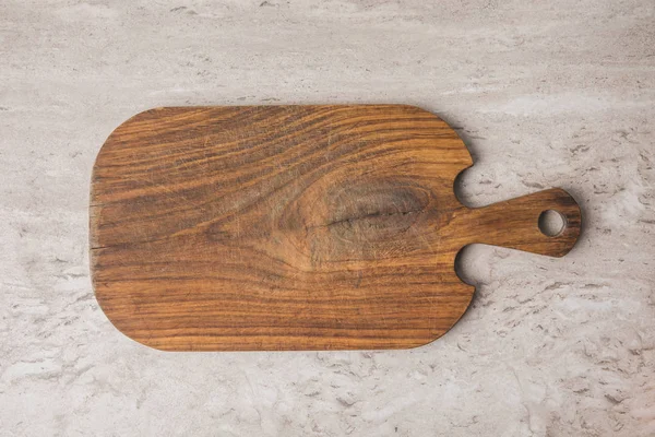 Top view of empty wooden cutting board on marble table — Stock Photo