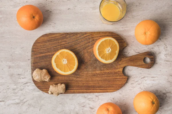 Vista dall'alto di taglio arancione e zenzero su tavola di legno — Foto stock